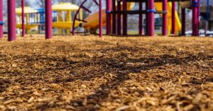 Playground maintenance crew refreshing mulch in spring.