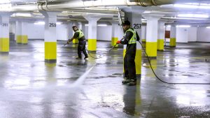 Underground garage being pressure‑washed to remove winter salt.